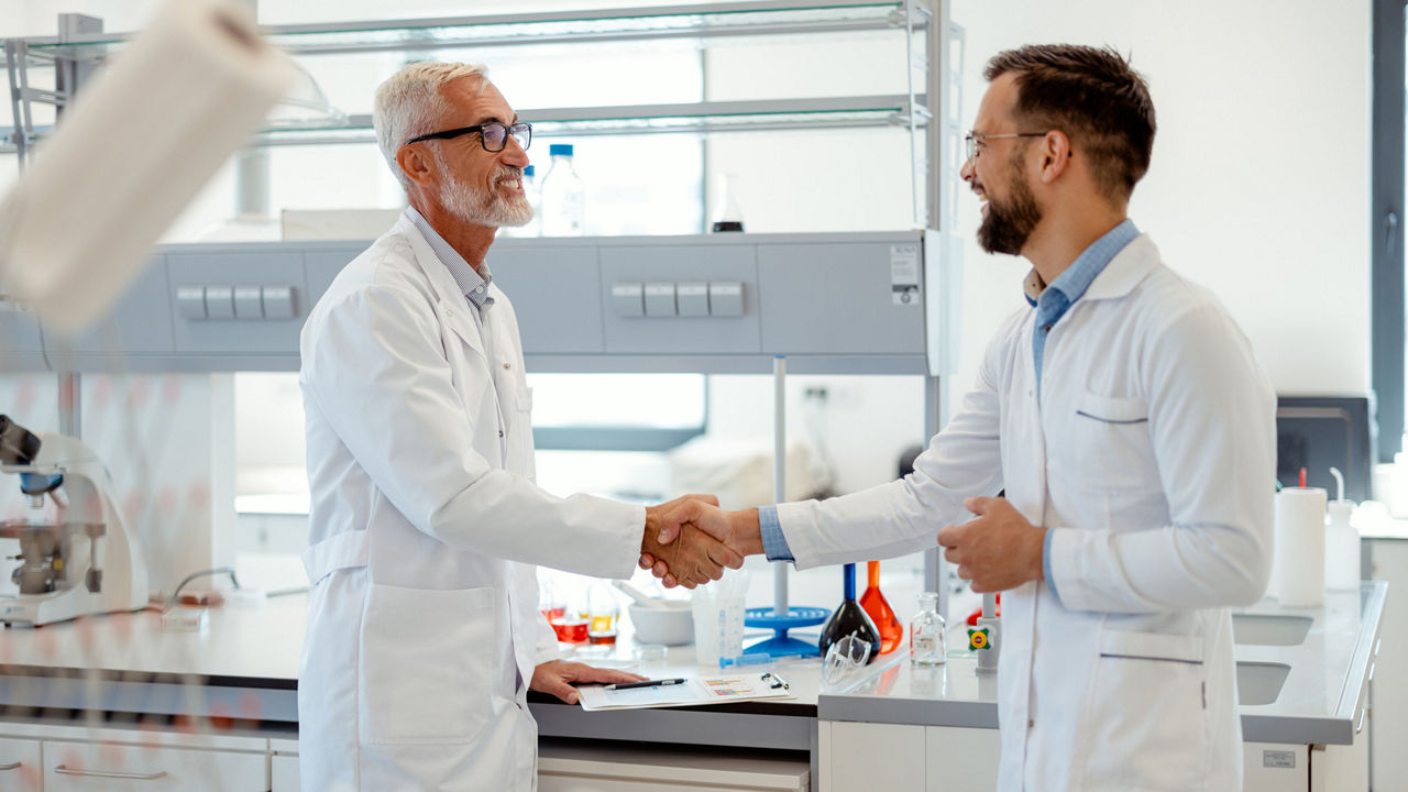 Image of Two Male Scientists Shake Hands in a Modern Laboratory