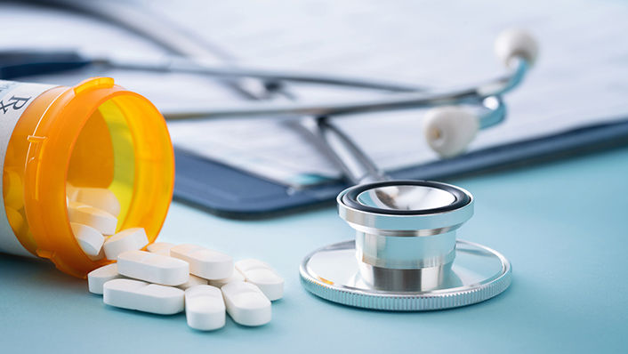 Image of prescription pills and a stethoscope